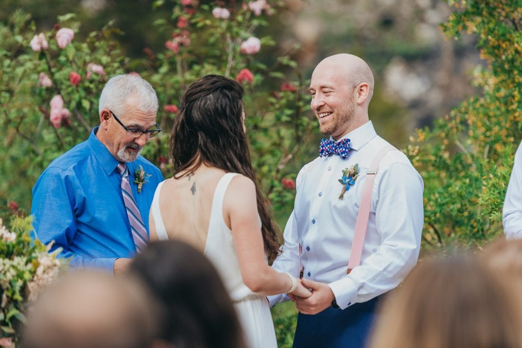 Bride and groom hold hands and say vows at Breckenridge, Colorado wedding