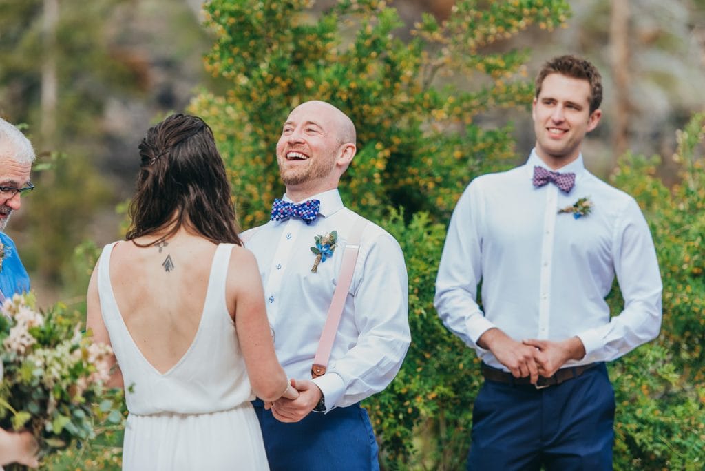 Groom with bowtie laughs during Breckenridge, Colorado outdoor wedding ceremony