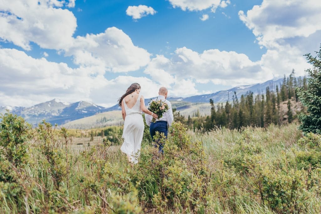 Bride and groom hike through Breckenridge, Colorado mountains on their wedding day