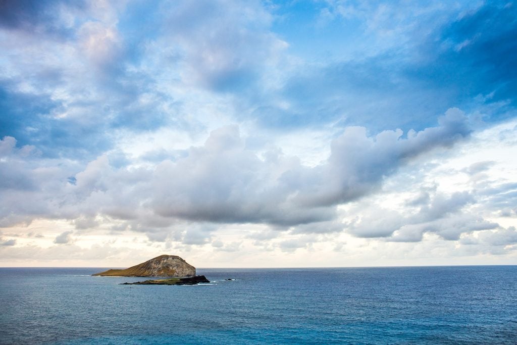 Hawaiian island in ocean with clouds. What you need to do to elope in Hawaii