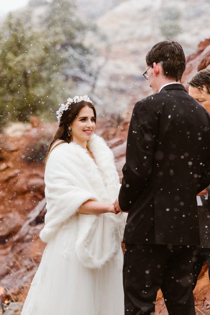 Bride in white fur shawl wrap says vows at her elopement