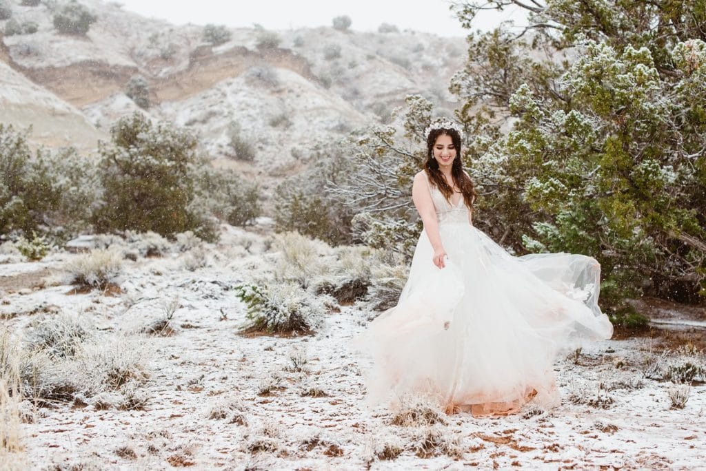 Bride swishes dress in the snow at Desert Harbor Retreat.